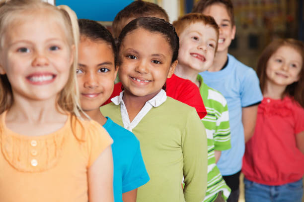 Young Elementary students smiling while waiting in line.